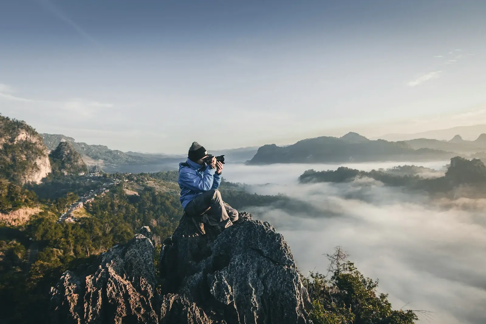 Hombre en la cima de la montaña tomando fotos